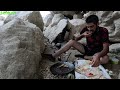 A nomadic man goes to a raging river and catches fish to prepare food for his family,village life