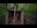 A man builds a log cabin in the forest. A dugout in the forest. Solo bushcraft