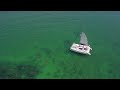 people snorkel by sailboat in clear ocean