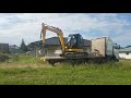 Crawler excavator JCB unloading from Volvo truck