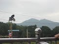 A bear on a dirtbike on a tightrope carrying a person