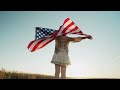 Woman Standing with American Stars and Stripes National Flag in Rural Wheat Field