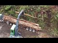 Log truck getting loaded by John Deere