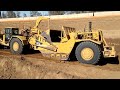 CAT 657G and 651B scrapers moving dirt - D9T Dozer ripping and pushing